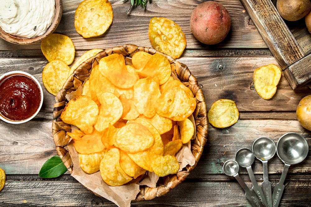 Potato chips in a basket with different sauces.
