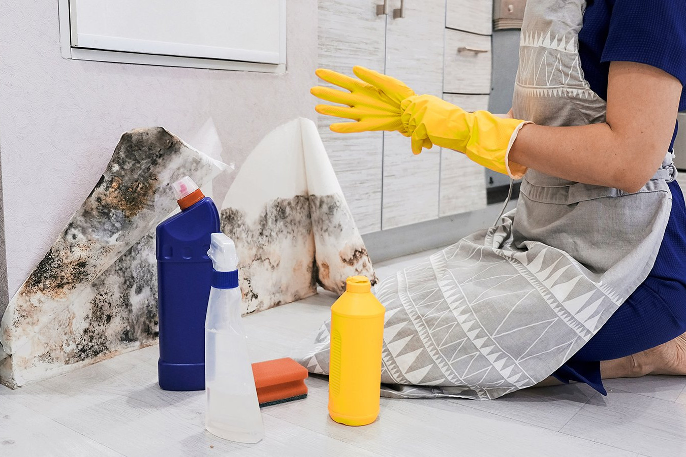 woman cleaning mold in kitchen