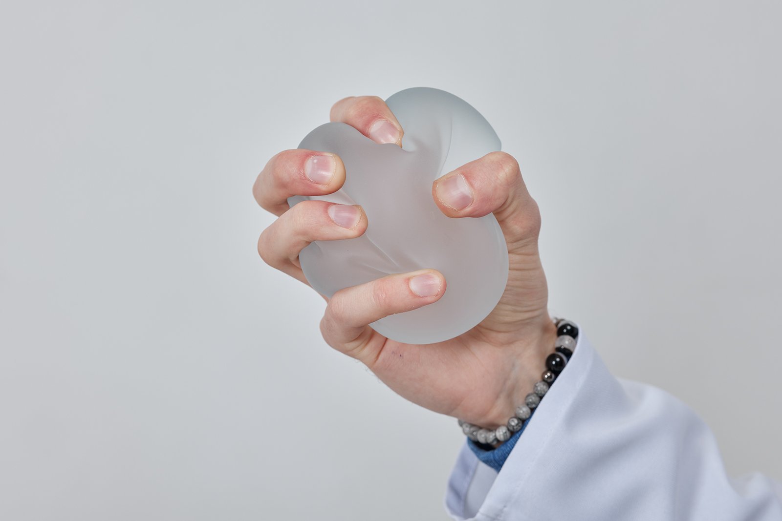 surgeon squeezing silicon implant